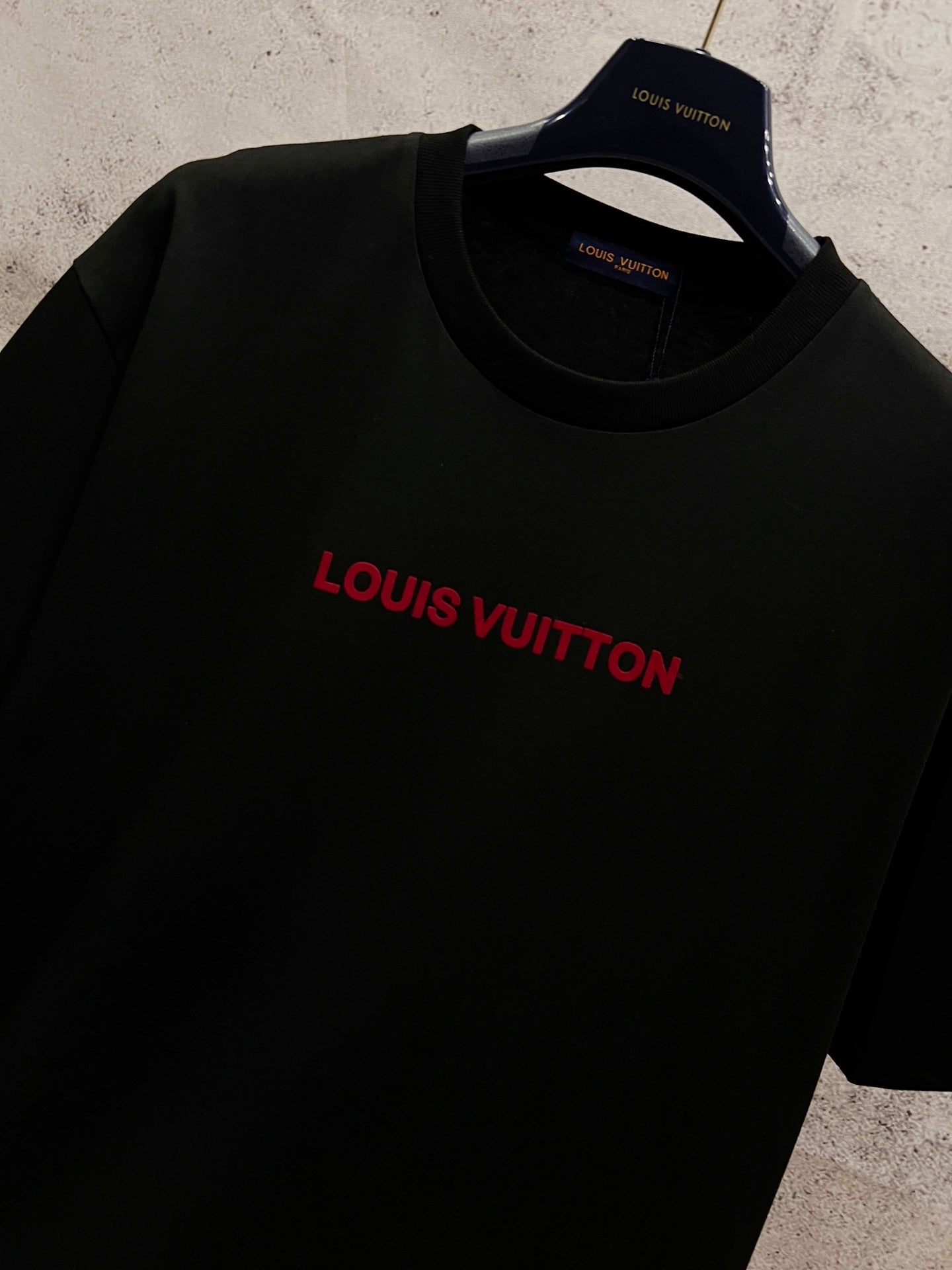 Black short-sleeve T-shirt with red Louis Vuitton logo centered on the chest