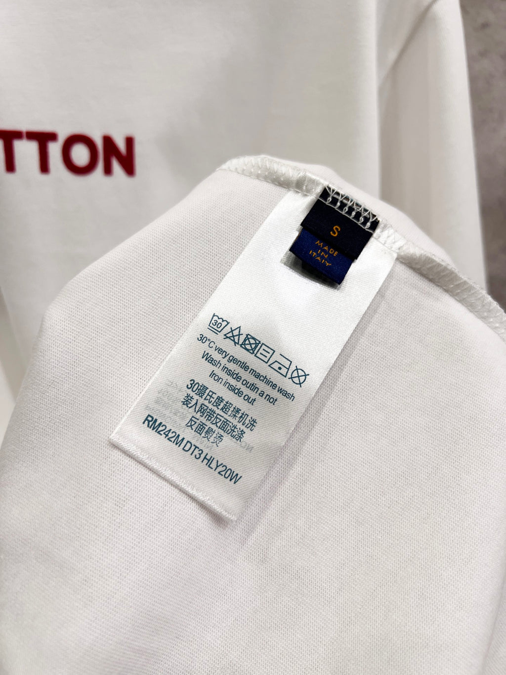 White T-shirt fabric close-up showing inner size and care label.