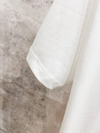 White T-shirt sleeve and shoulder seam detail.