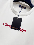 White T-shirt with red Louis Vuitton logo, plus black hang tag attached by string.