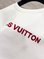 White T-shirt close-up with red Louis Vuitton lettering across the chest.