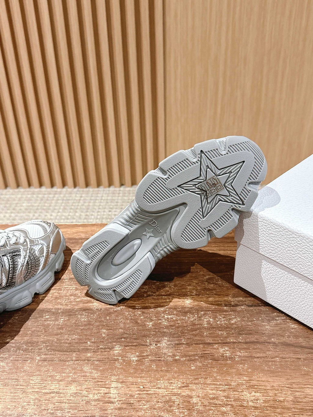 Outsole of silver Dior sneaker showing star pattern traction tread