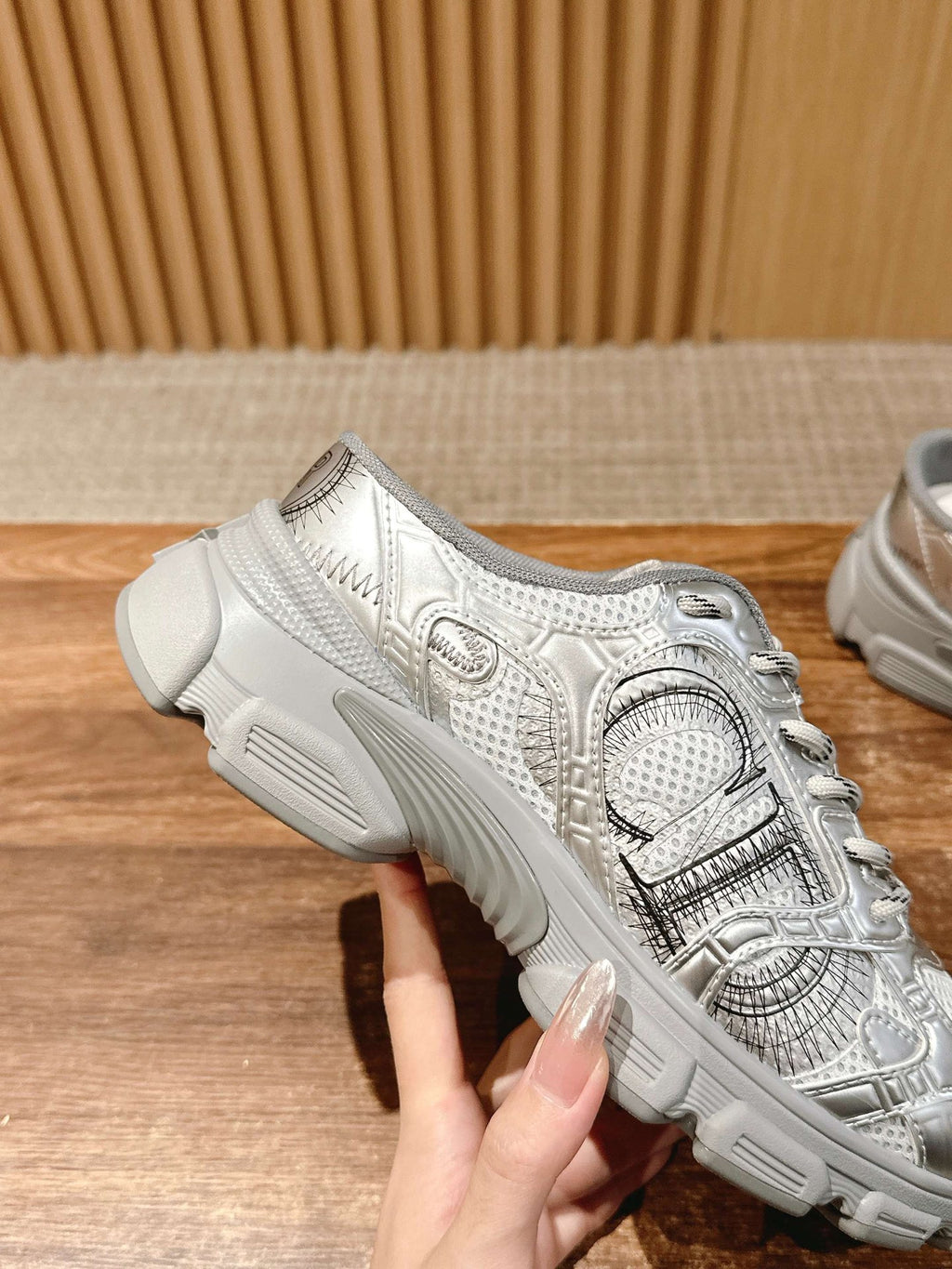 Silver metallic lace-up sneaker with textured straps and molded gray midsole