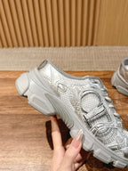 Silver metallic lace-up sneaker with textured straps and molded gray midsole