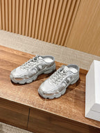 Pair of silver metallic lace-up sneakers on a wooden surface with gray soles