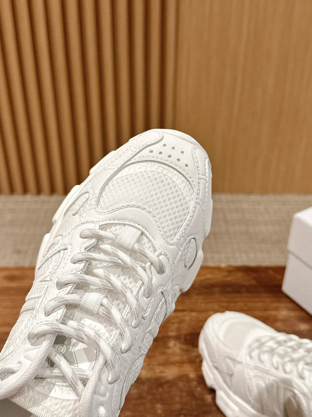 White Dior sneaker close-up on the upper, laces and perforated panel details