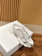 White Dior lace-up sneaker shown on a box, side view