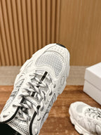 Close view of a white sneaker upper with patterned overlay and black laces