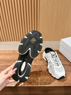 Pair view: black rubber outsole and white lace-up sneaker with black laces