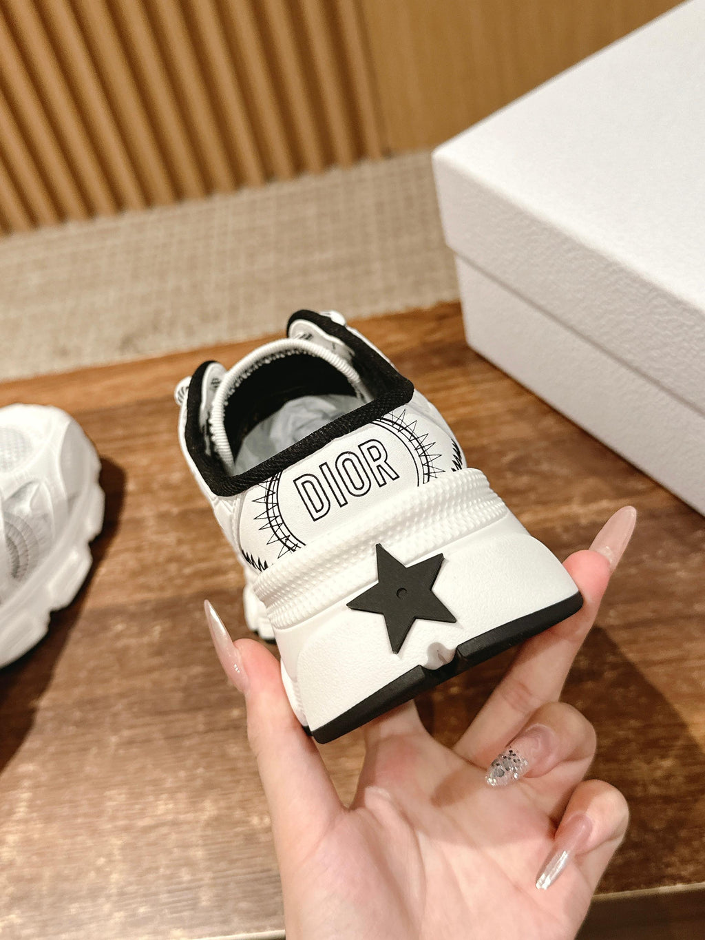 White sneaker with Dior text on heel tab and black star patch