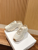 Pair of white lace-up sneakers on shoebox, chunky sole detail