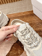 White lace-up sneaker close-up with mesh upper and layered laces