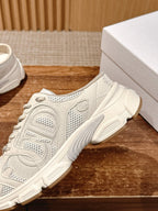 White lace-up sneaker side view, textured mesh panels and thick ridged sole