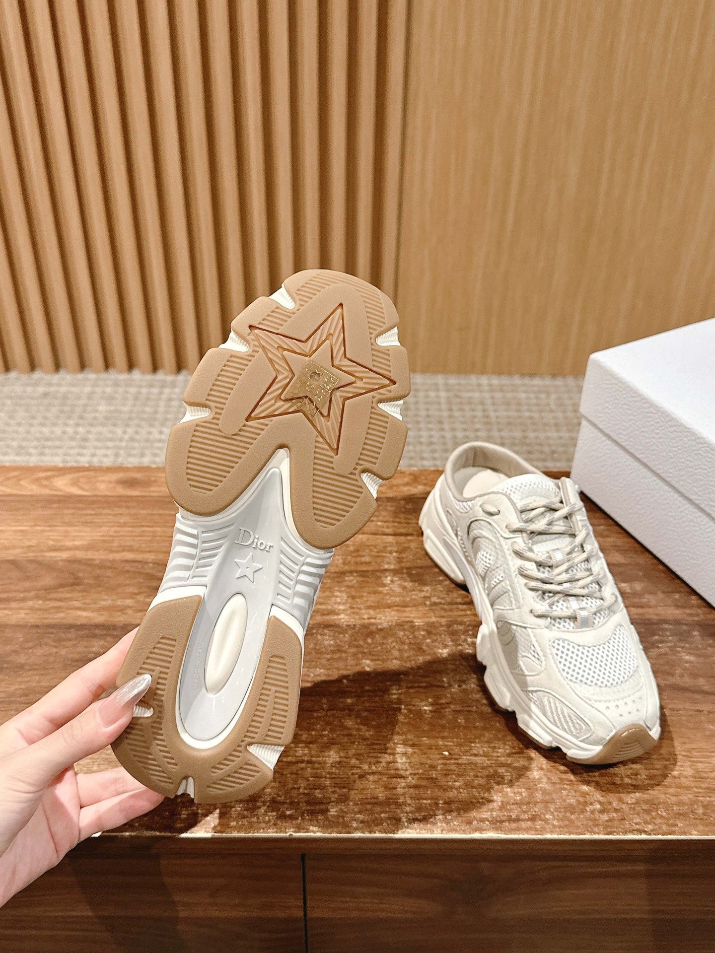 White sneaker outsole view with star tread detail and matching lace-up shoe