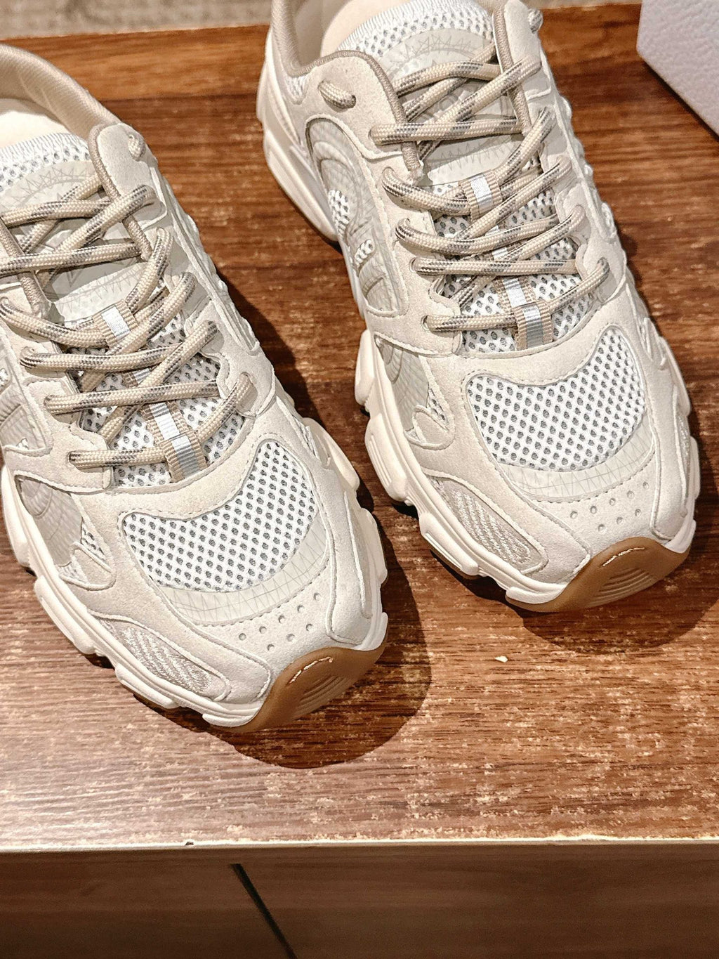 Two white lace-up sneakers side view, perforated panels and chunky rubber sole