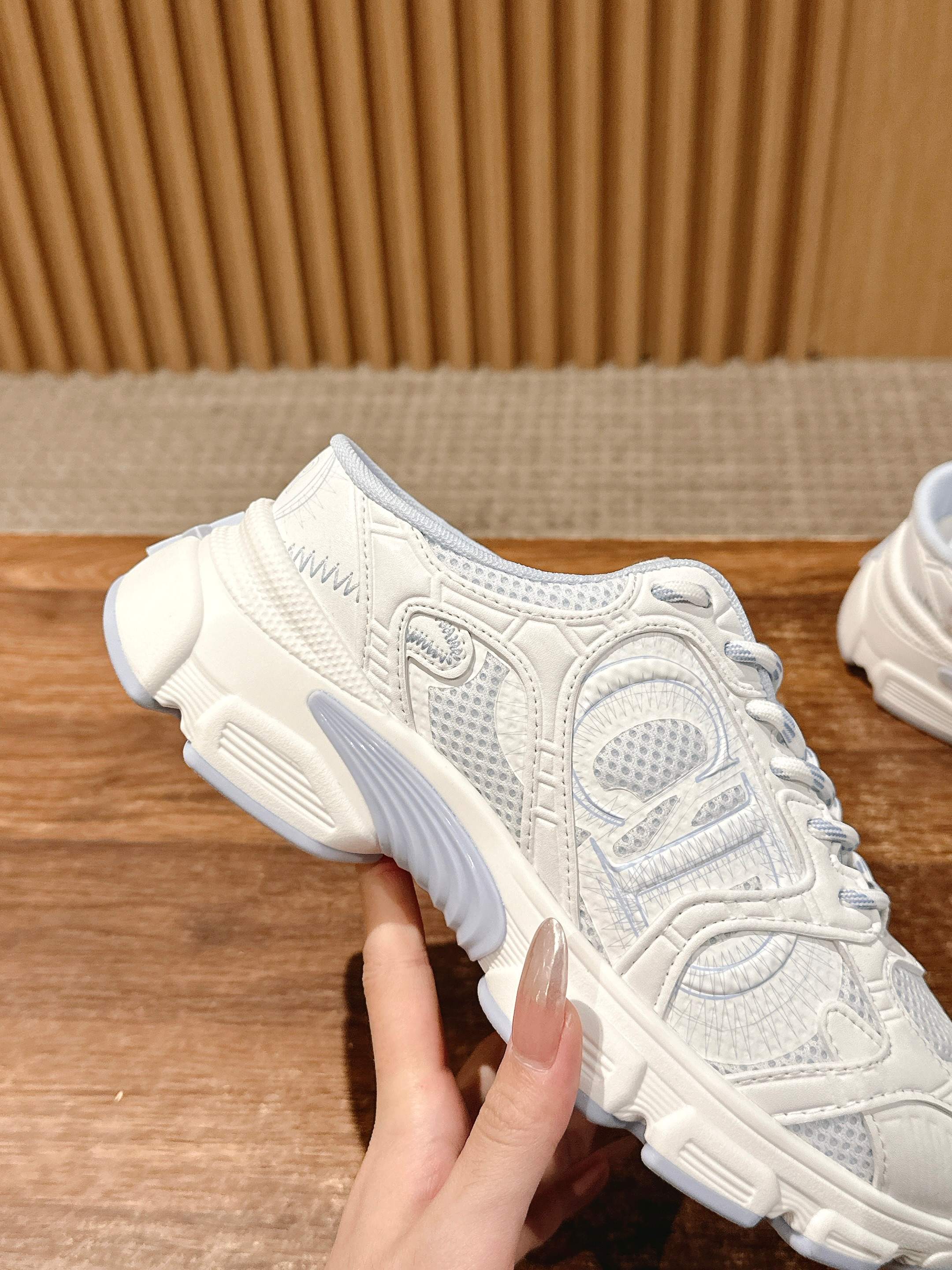 White Dior lace-up sneaker close-up with detailed panel stitching