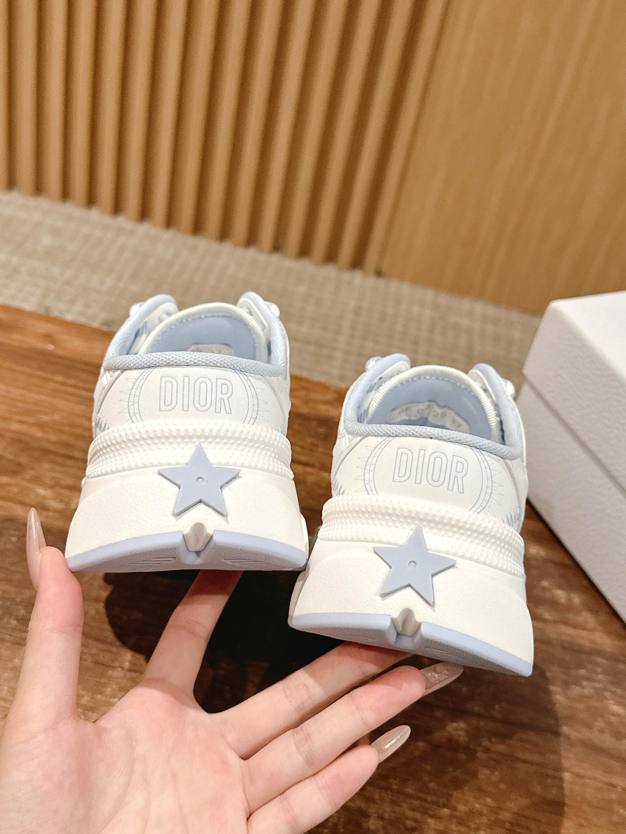 White Dior sneakers showing back DIOR lettering and star patch on heel
