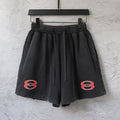 Black Balenciaga shorts with elastic waistband, drawstring, and red logo on each leg