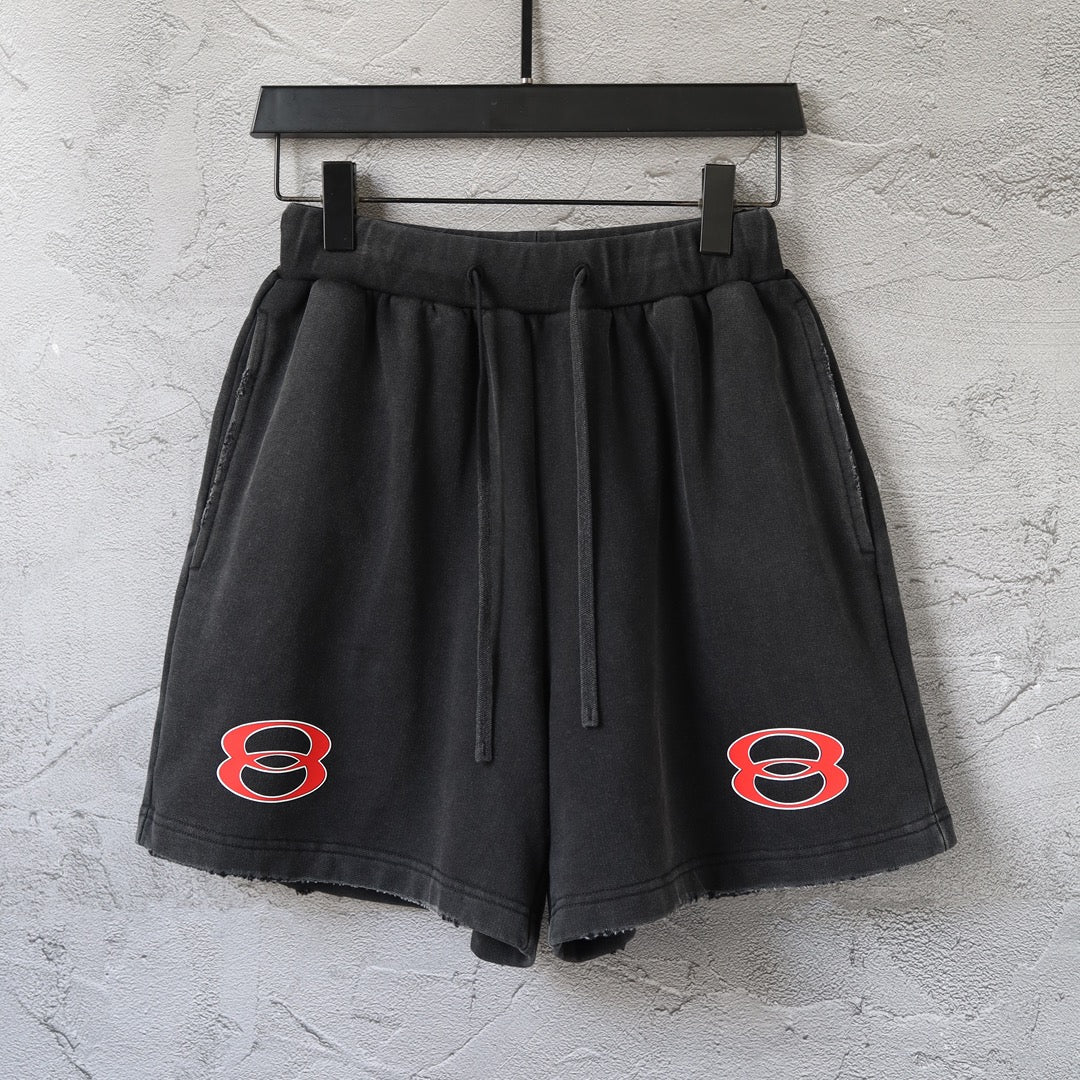 Black Balenciaga shorts with elastic waistband, drawstring, and red logo on each leg
