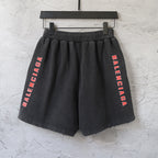 Black Balenciaga shorts with elastic waistband and vertical red Balenciaga text on both legs