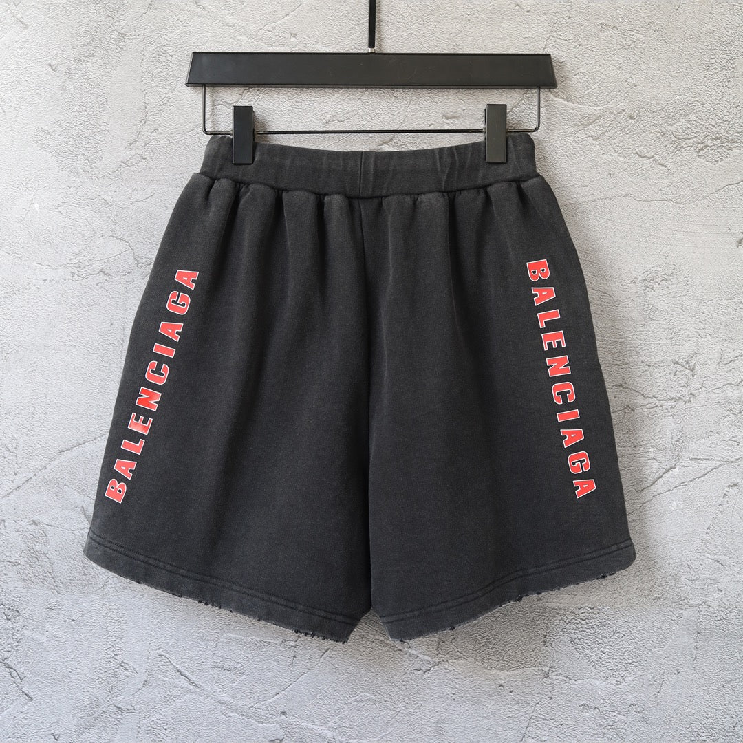 Black Balenciaga shorts with elastic waistband and vertical red Balenciaga text on both legs
