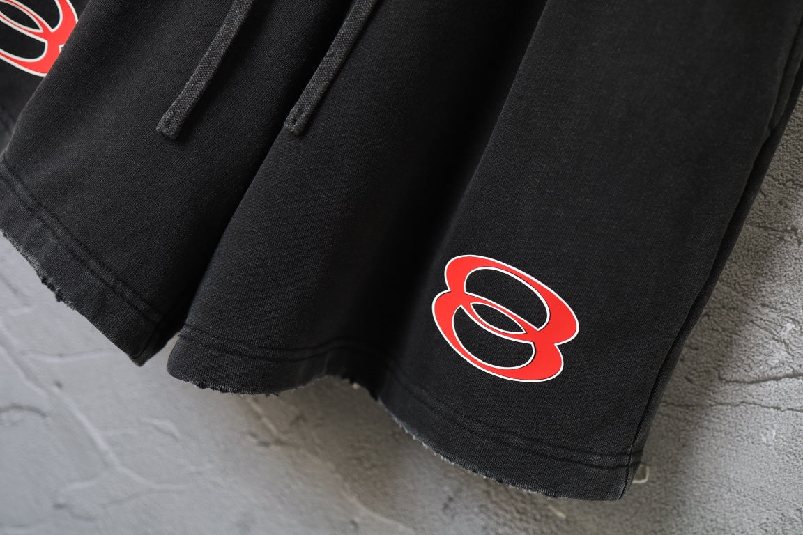 Black Balenciaga shorts with red logo print on the lower leg