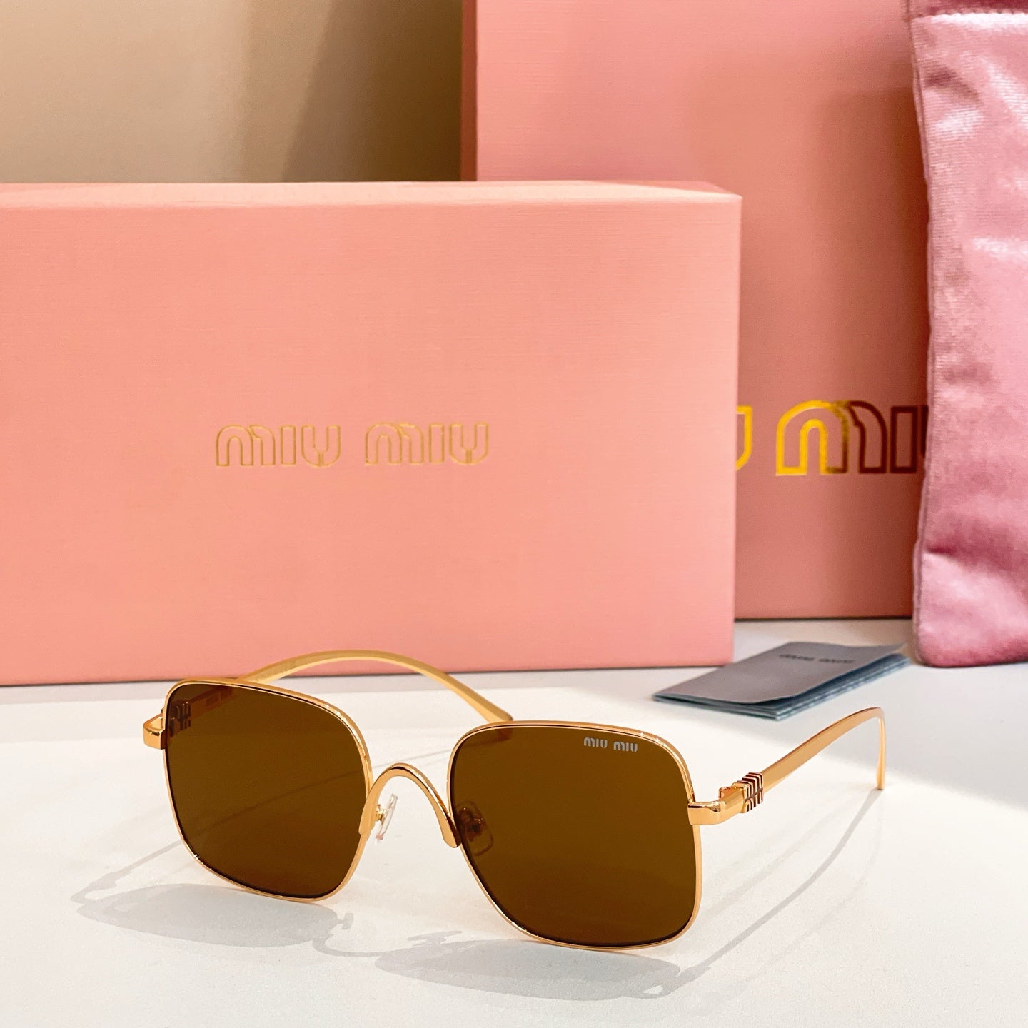 Gold-framed square sunglasses with dark brown-tinted lenses