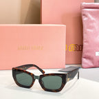 MiuMiu sunglasses with dark tortoiseshell frames and dark green tinted lenses.