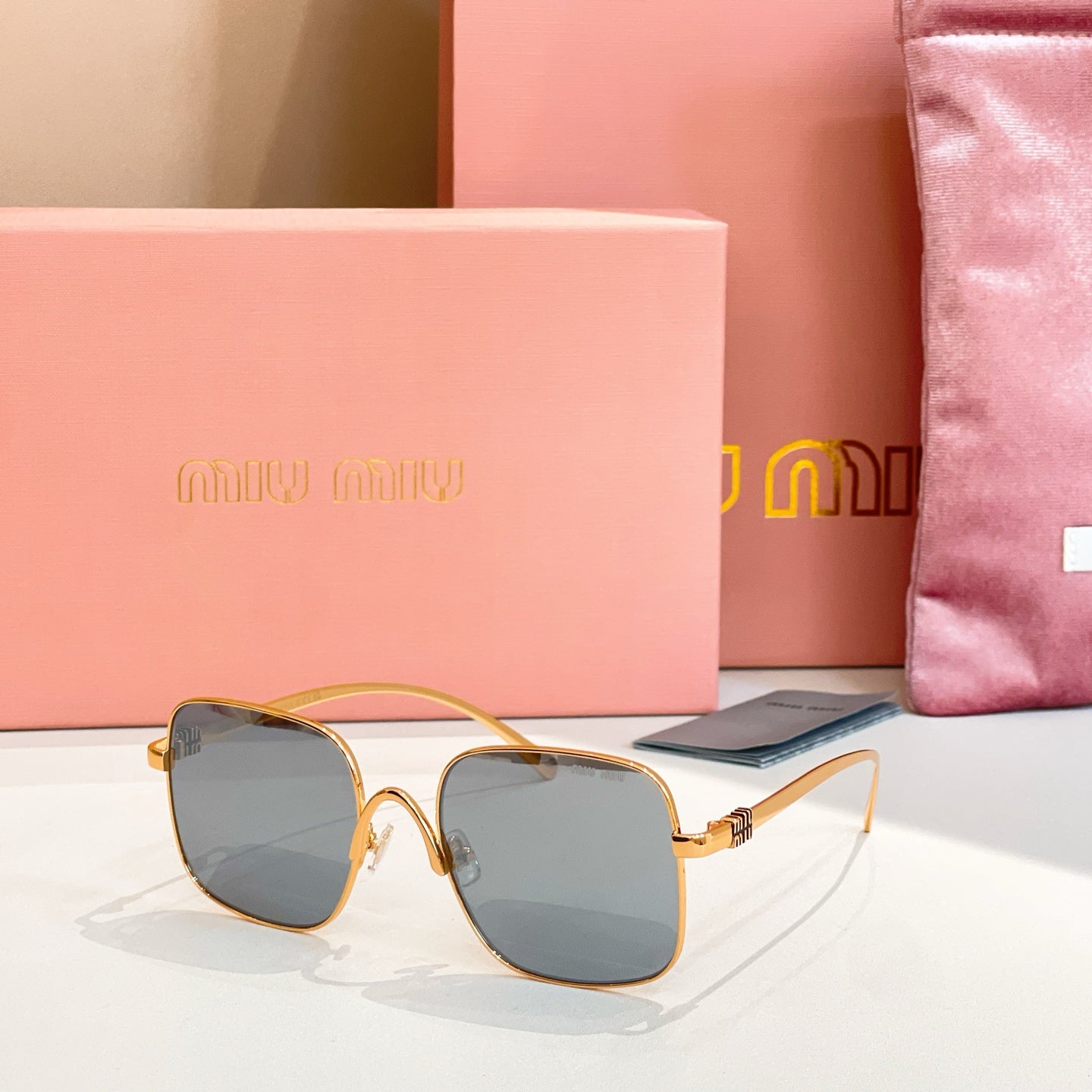 Gold-framed square sunglasses with dark gray-tinted lenses