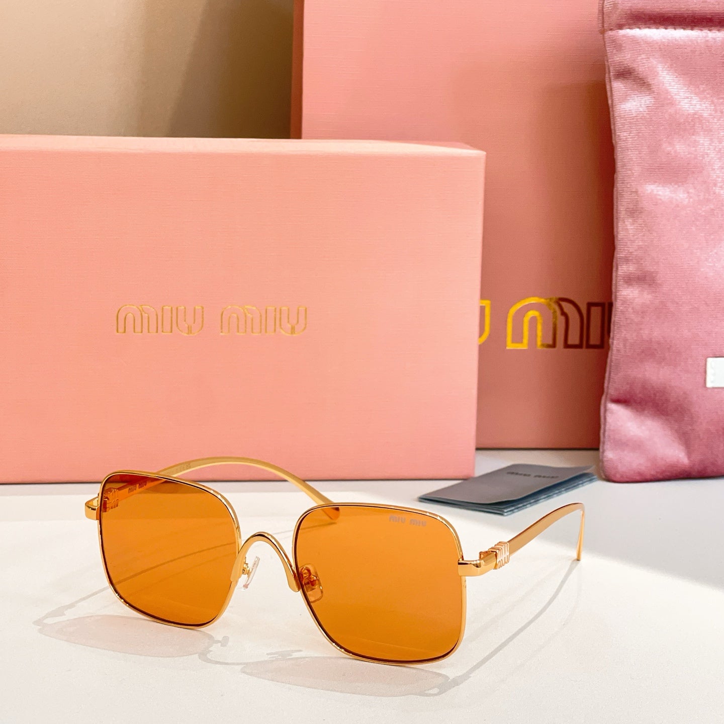 Gold-framed square sunglasses with orange-tinted lenses