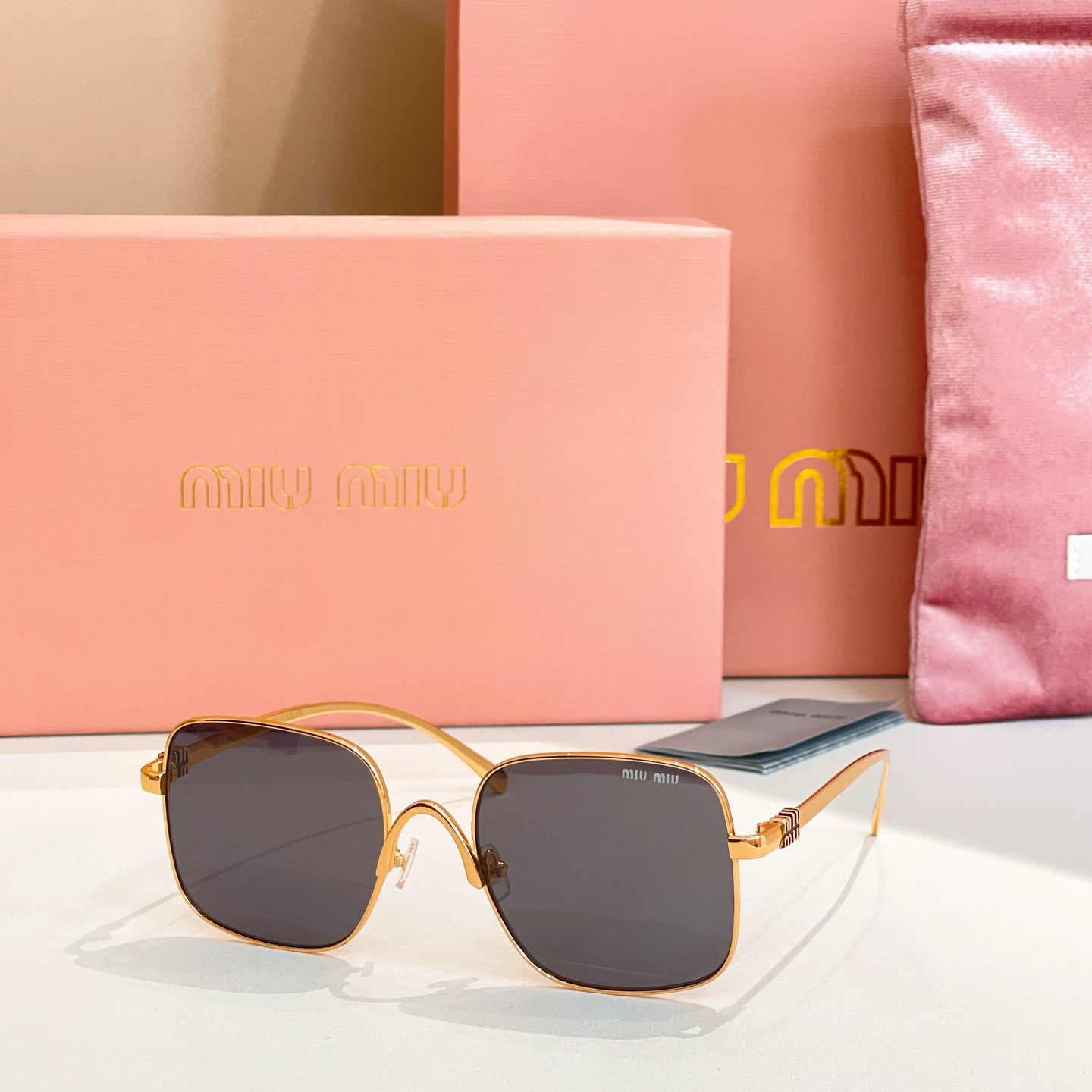 Gold-framed square sunglasses with dark gray-tinted lenses
