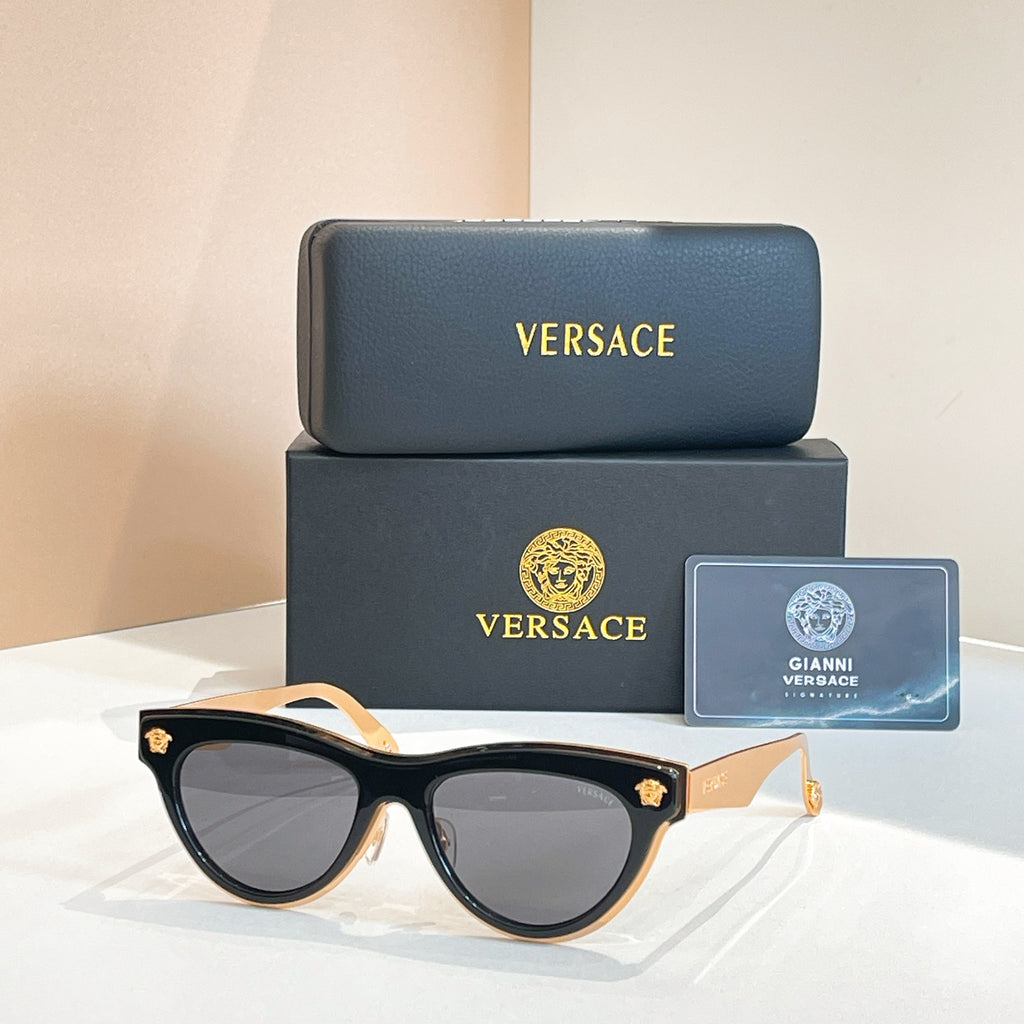 Versace sunglasses, black cat-eye frames with dark tinted lenses and gold logo temples
