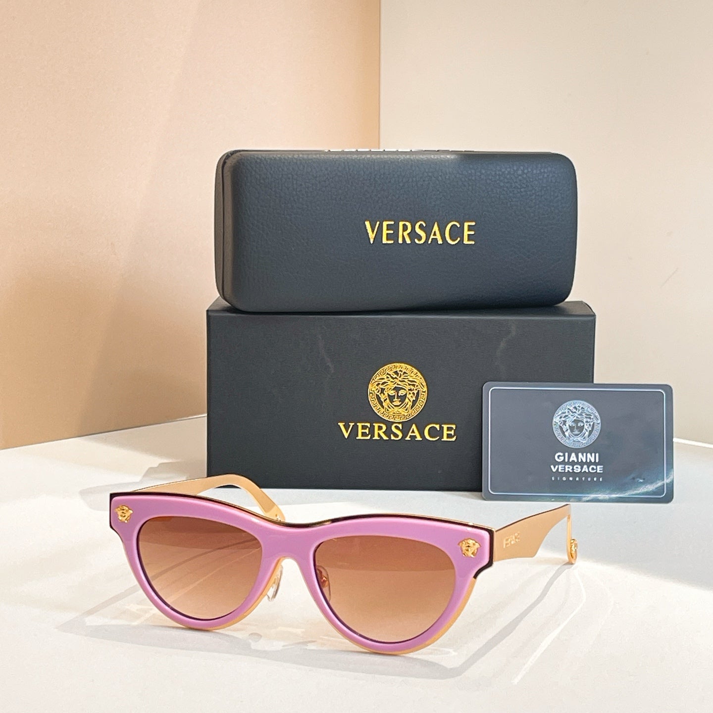 Versace sunglasses, light purple cat-eye frames with tinted lenses and gold logo temples