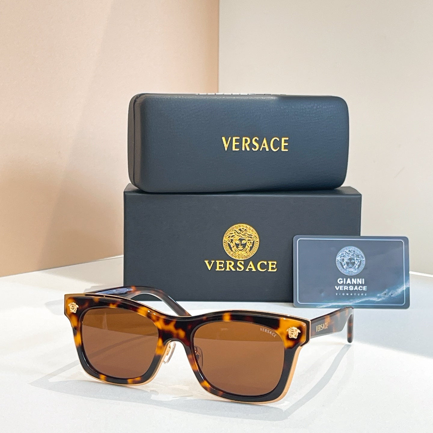 Versace sunglasses with tortoiseshell brown frames, round-square lenses, and gold emblem