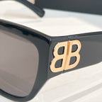 Black sunglasses with gold-tone "B" logo on the temple
