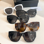 Assorted sunglasses with dark lenses in black, white, and tortoiseshell frames