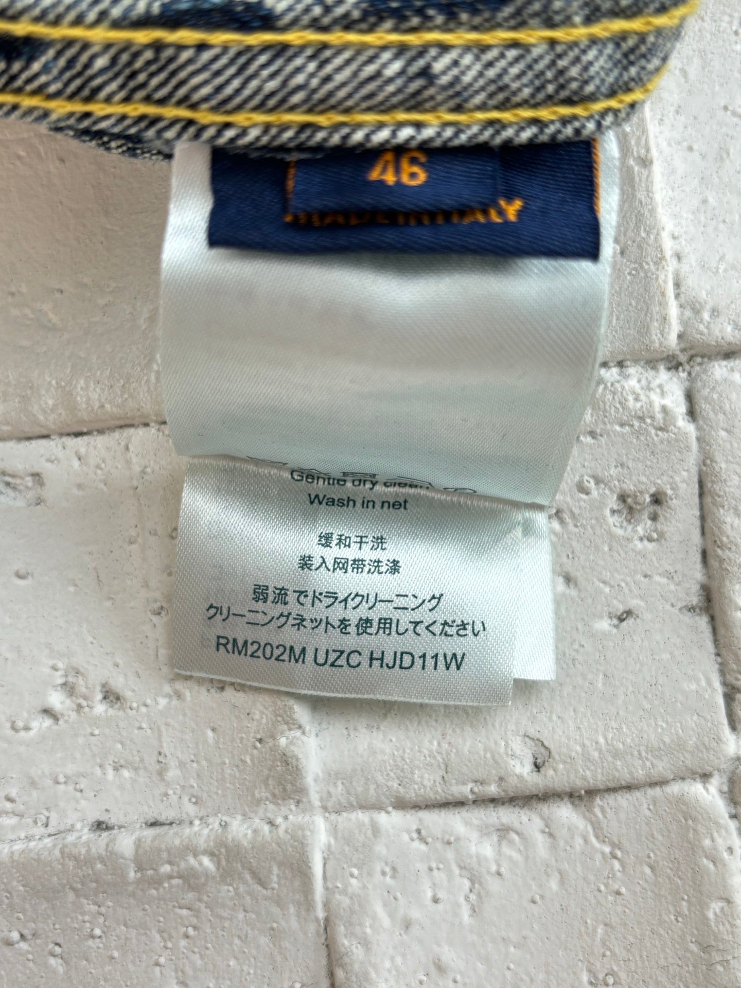 Denim shorts care label with size 46 and wash instructions