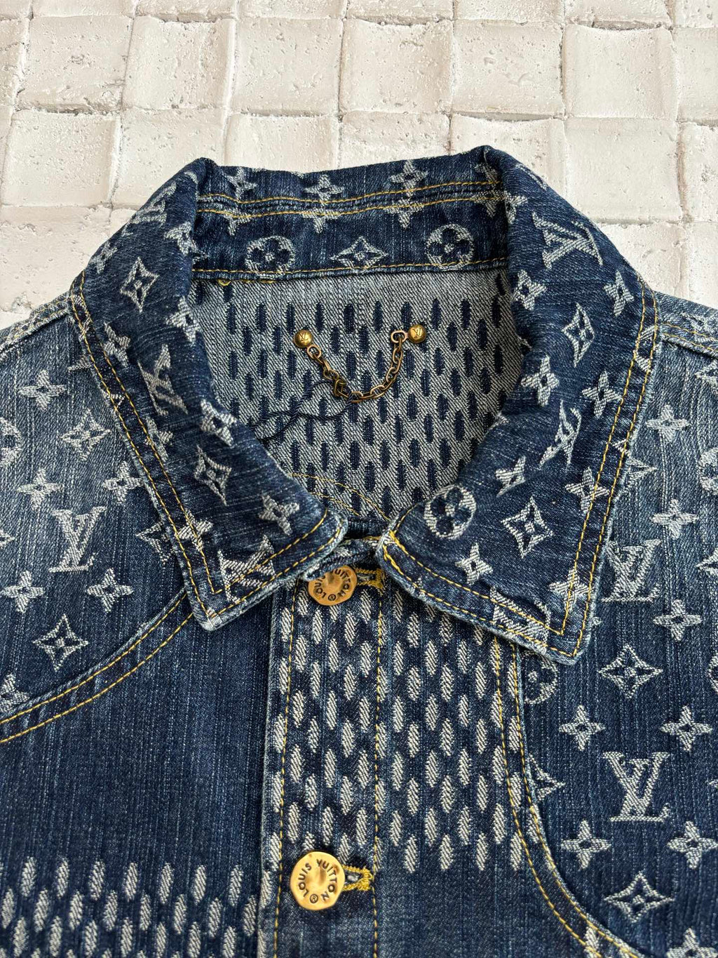 Louis Vuitton denim jacket close-up with blue monogram interior yoke and gold buttons