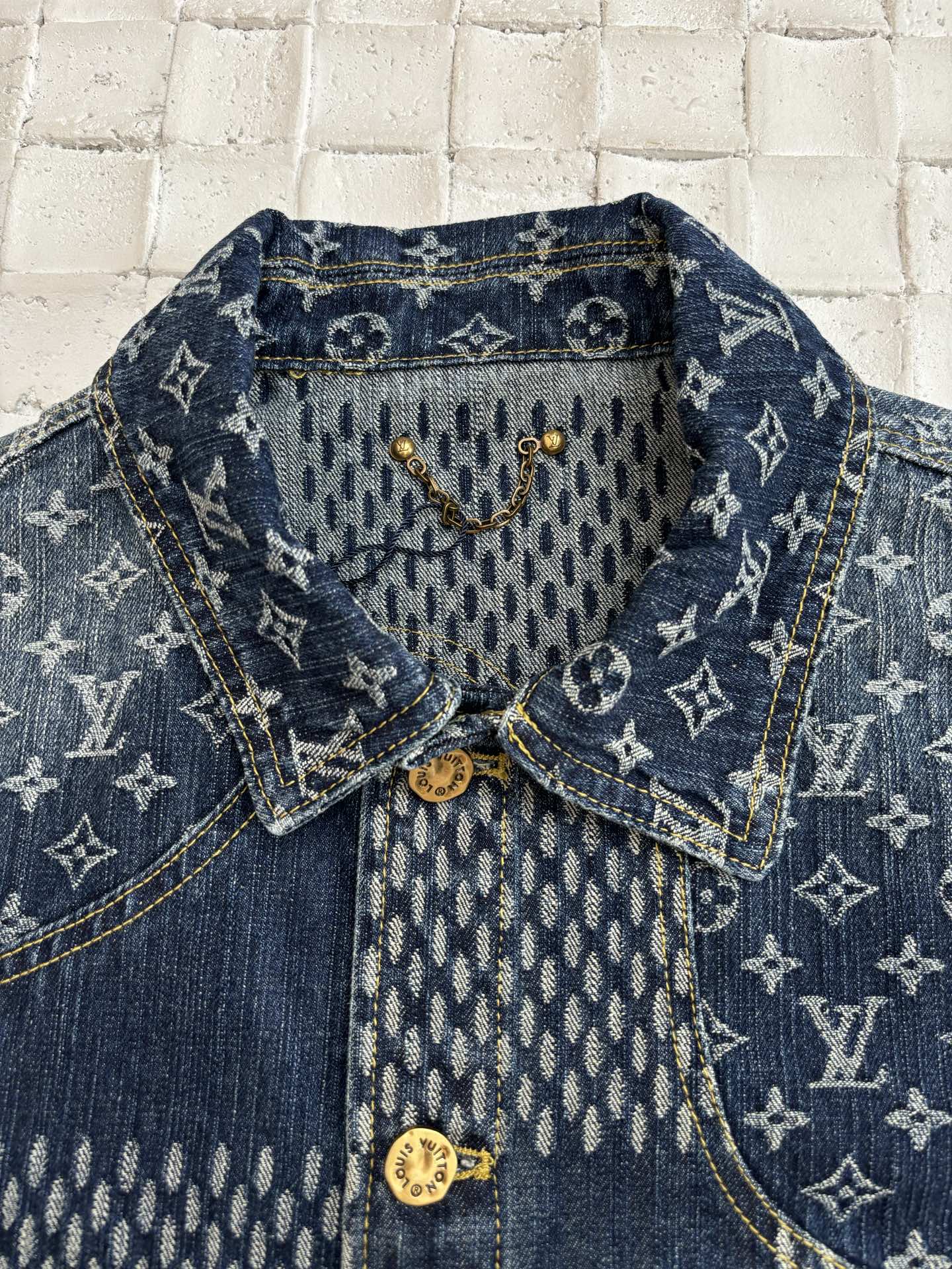 Louis Vuitton denim jacket close-up with blue monogram interior yoke and gold buttons