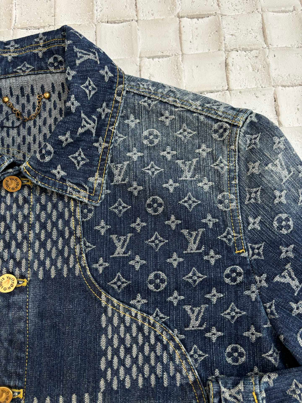 Louis Vuitton denim jacket close-up with blue monogram pattern panels and gold trim