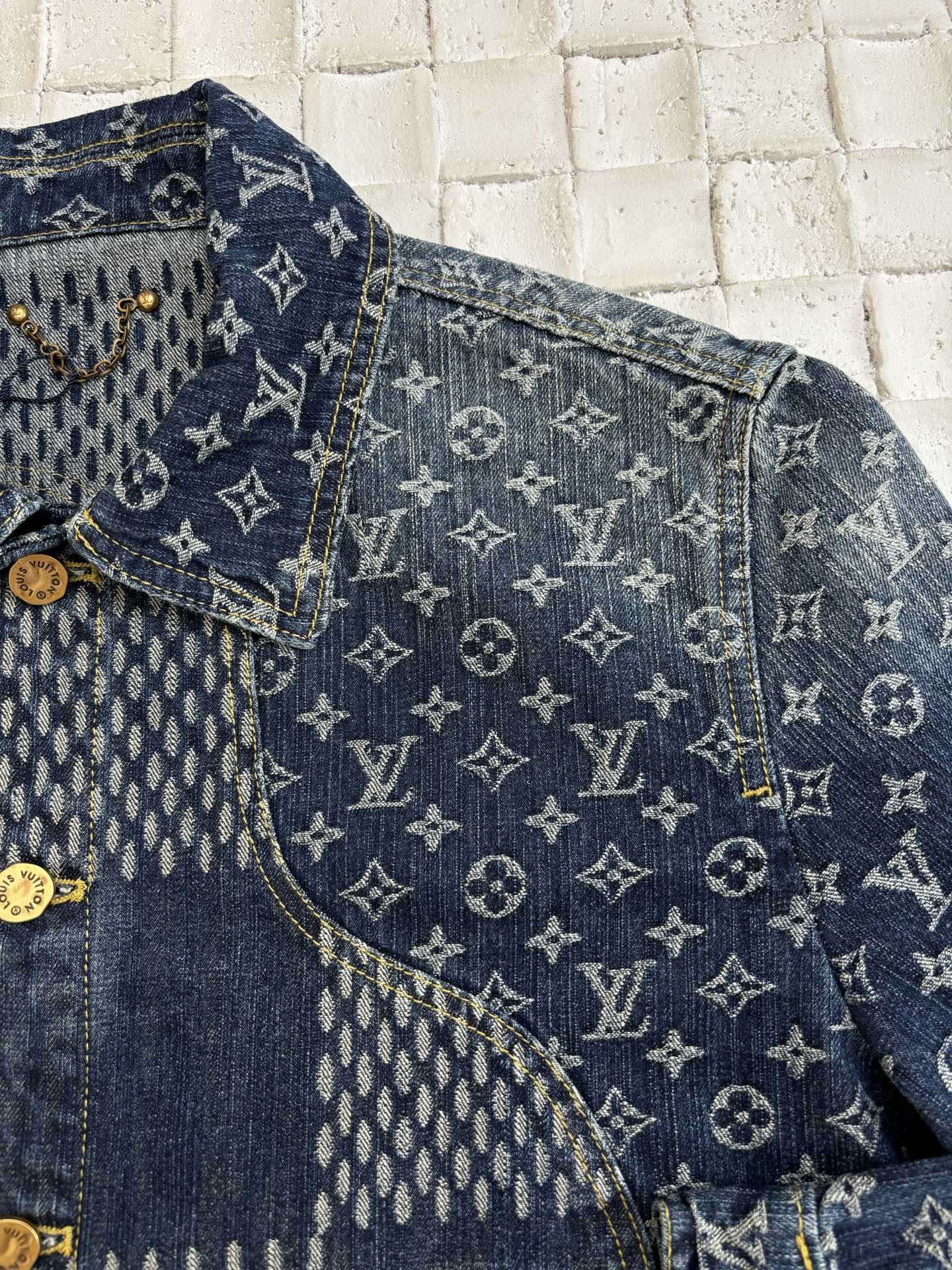 Louis Vuitton denim jacket close-up with blue monogram pattern panels and gold trim