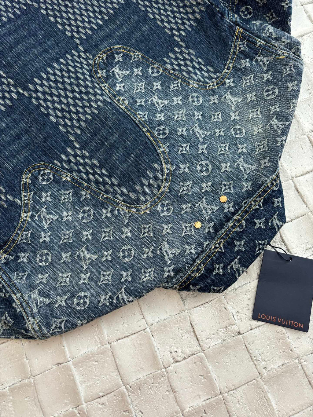 Louis Vuitton denim jacket close-up with blue monogram collar and gold button placket