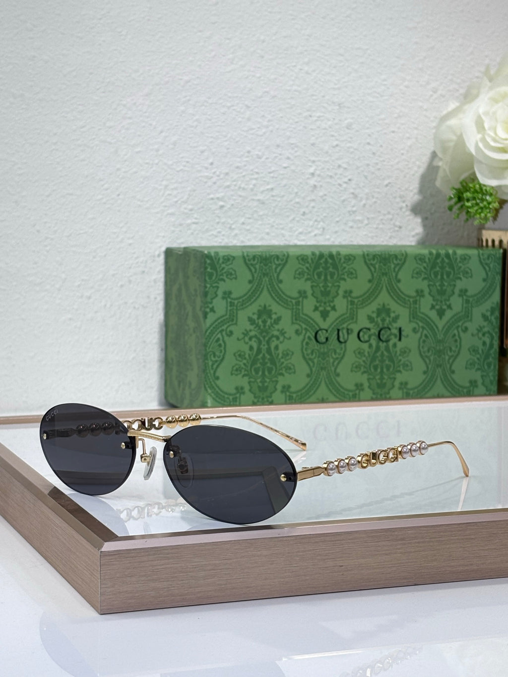 Gold-tone round sunglasses with dark lenses and decorative chain links on temples