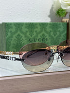 Round sunglasses with dark lenses on gold-tone frames, on display in a pair