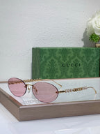 Gold-tone round sunglasses with pink lenses and decorative chain detail on temples