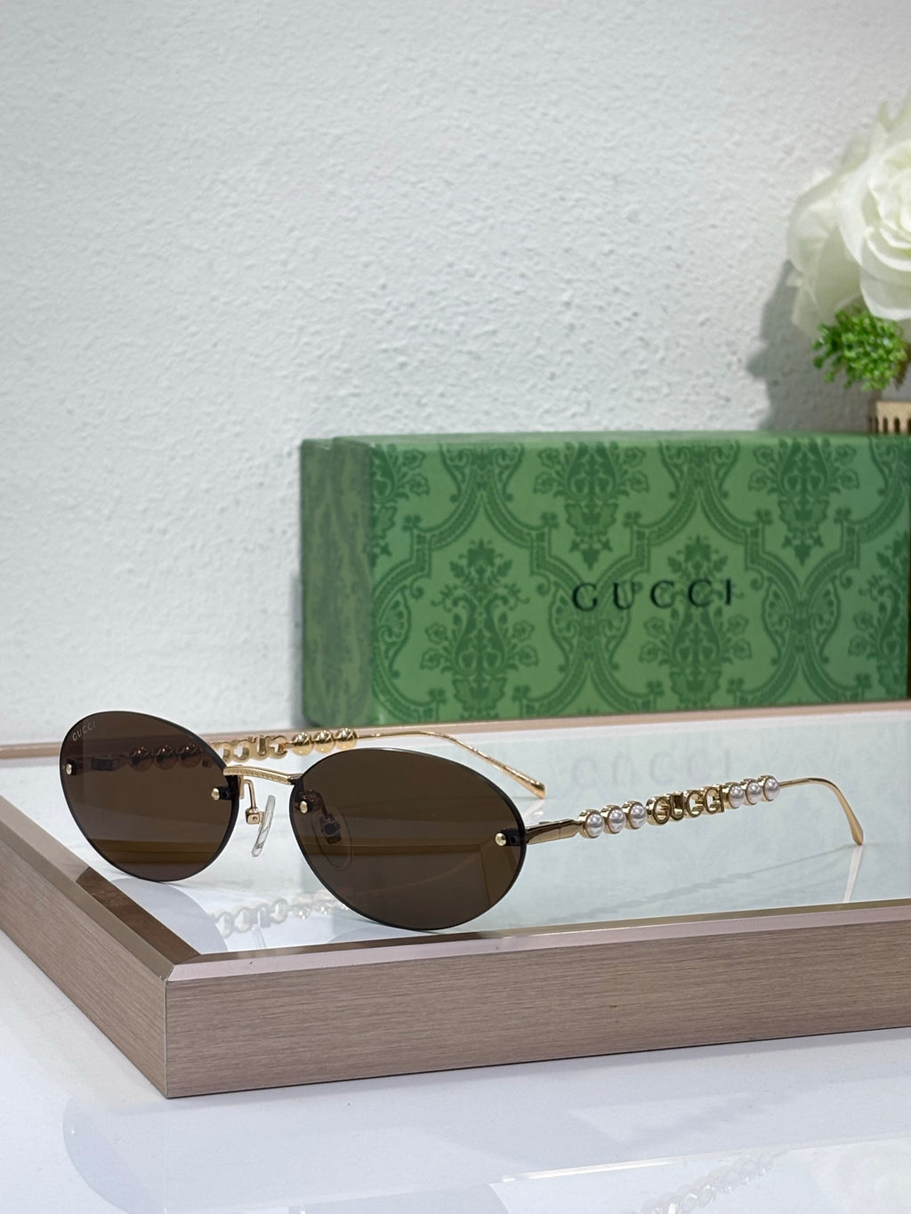 Gold-tone round sunglasses with dark lenses and ornate chain temple accents
