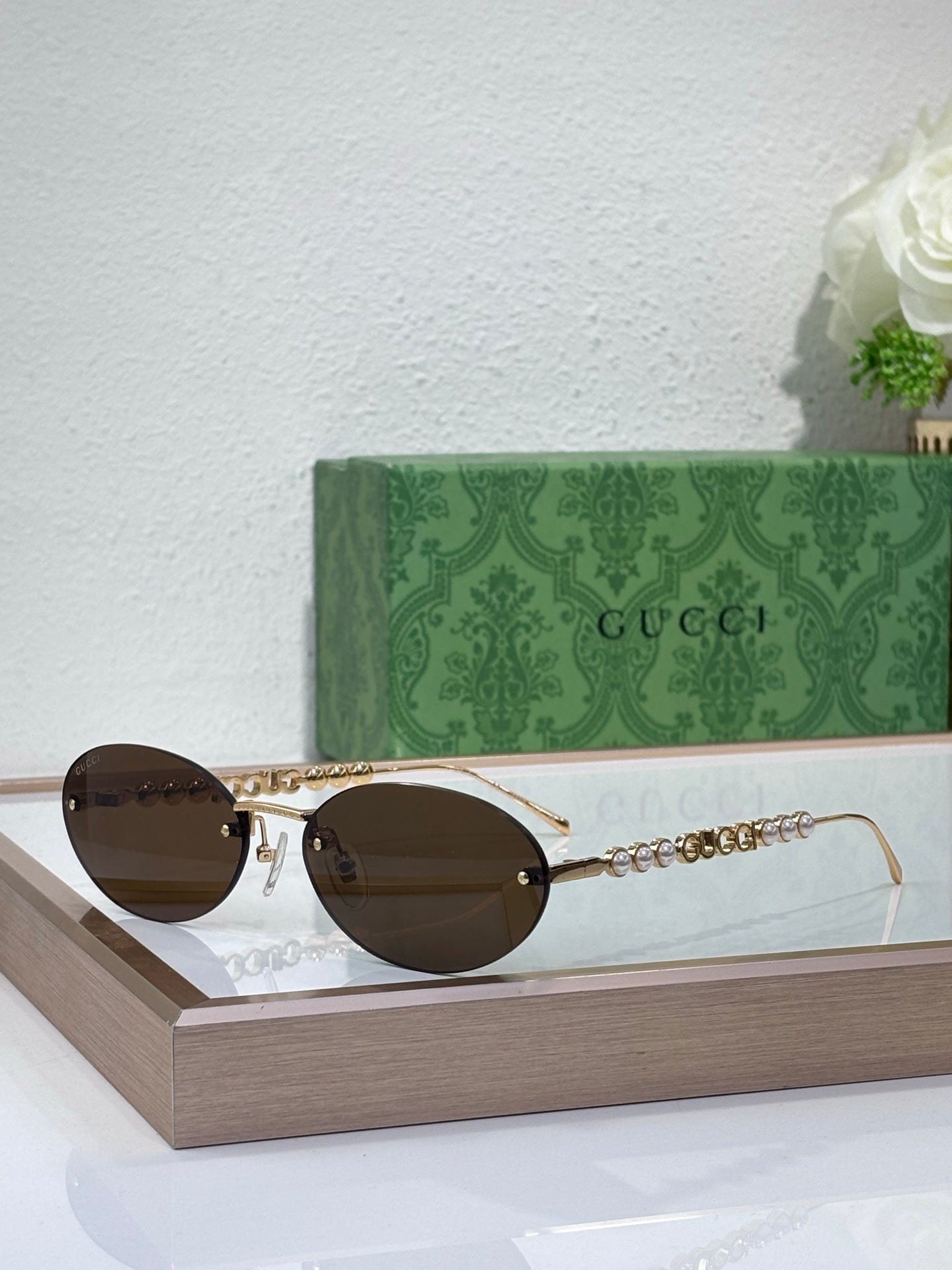Gold-tone round sunglasses with dark lenses and ornate chain temple accents