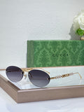 Gold-tone round sunglasses with dark lenses and decorative chain detail on temples