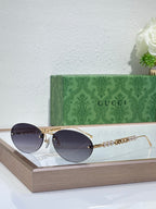 Gold-tone round sunglasses with dark lenses and decorative chain detail on temples
