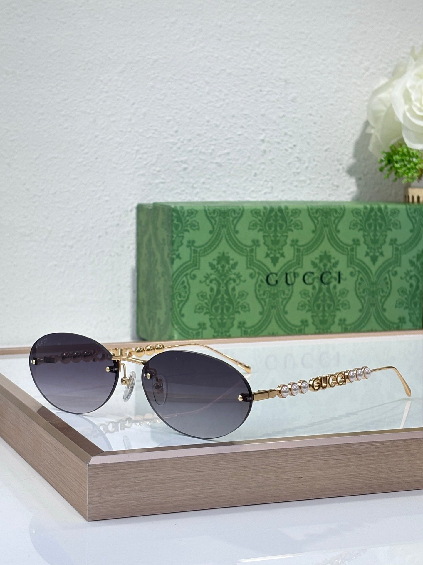 Gold-tone round sunglasses with dark lenses and decorative chain detail on temples